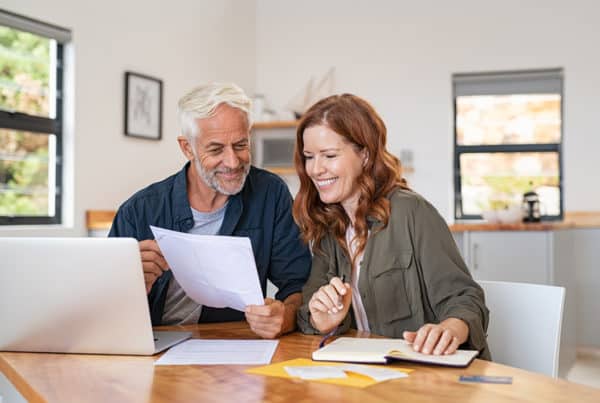 a couple happily reading a paper in front of the dining table