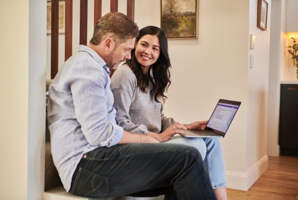 Man and woman in casual attire sitting together using a laptop