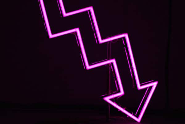 an image of a neon pink downward zig-zagging arrow