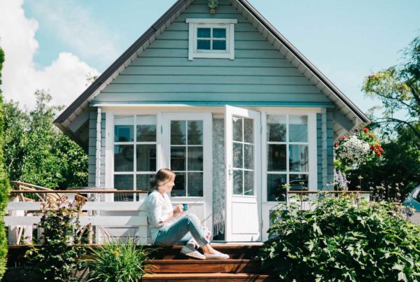 lady sitting on the stairs in front of a house