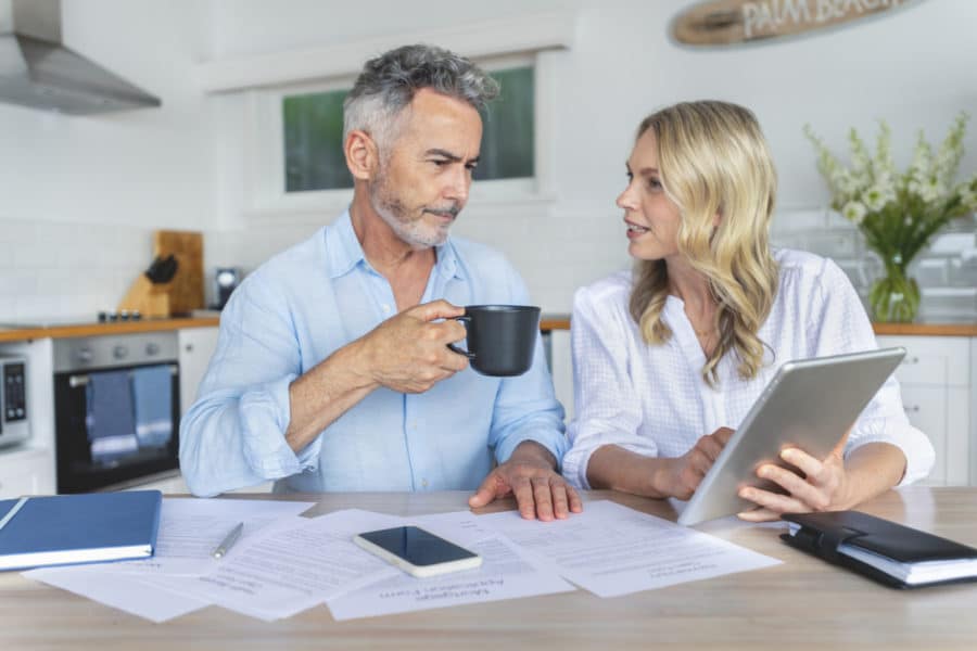 Mature couple doing paperwork and paying bills at home.