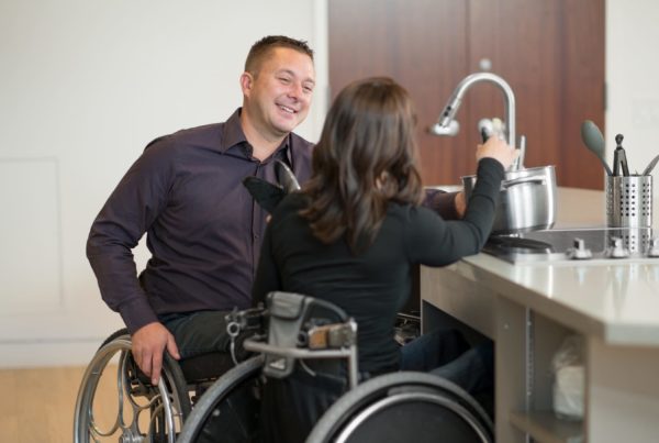 A couple in wheelchairs in the kitche