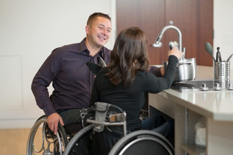 A couple in wheelchairs in the kitche